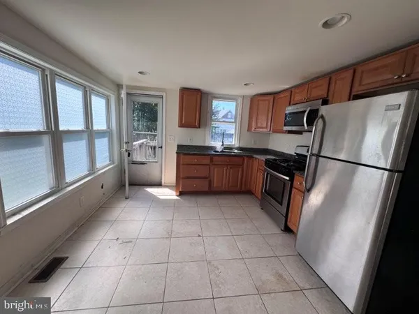 a kitchen with granite countertop a refrigerator and a stove top oven