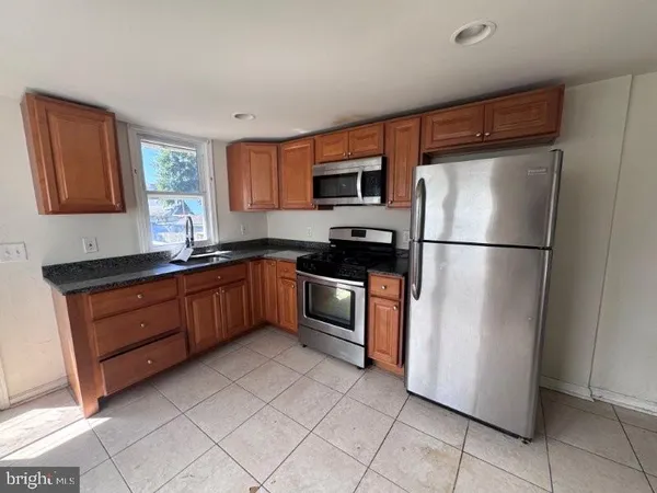 a kitchen with stainless steel appliances granite countertop a refrigerator a sink and a stove