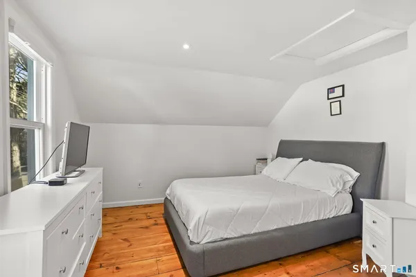 a bedroom with a bed and a flat tv screen on the dresser