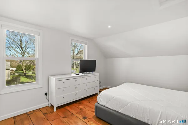 a bedroom with a bed and a flat tv screen on the dresser