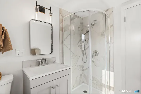 a bathroom with a sink vanity granite shower and a mirror