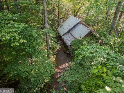 a backyard of a house with table and chairs under an umbrella