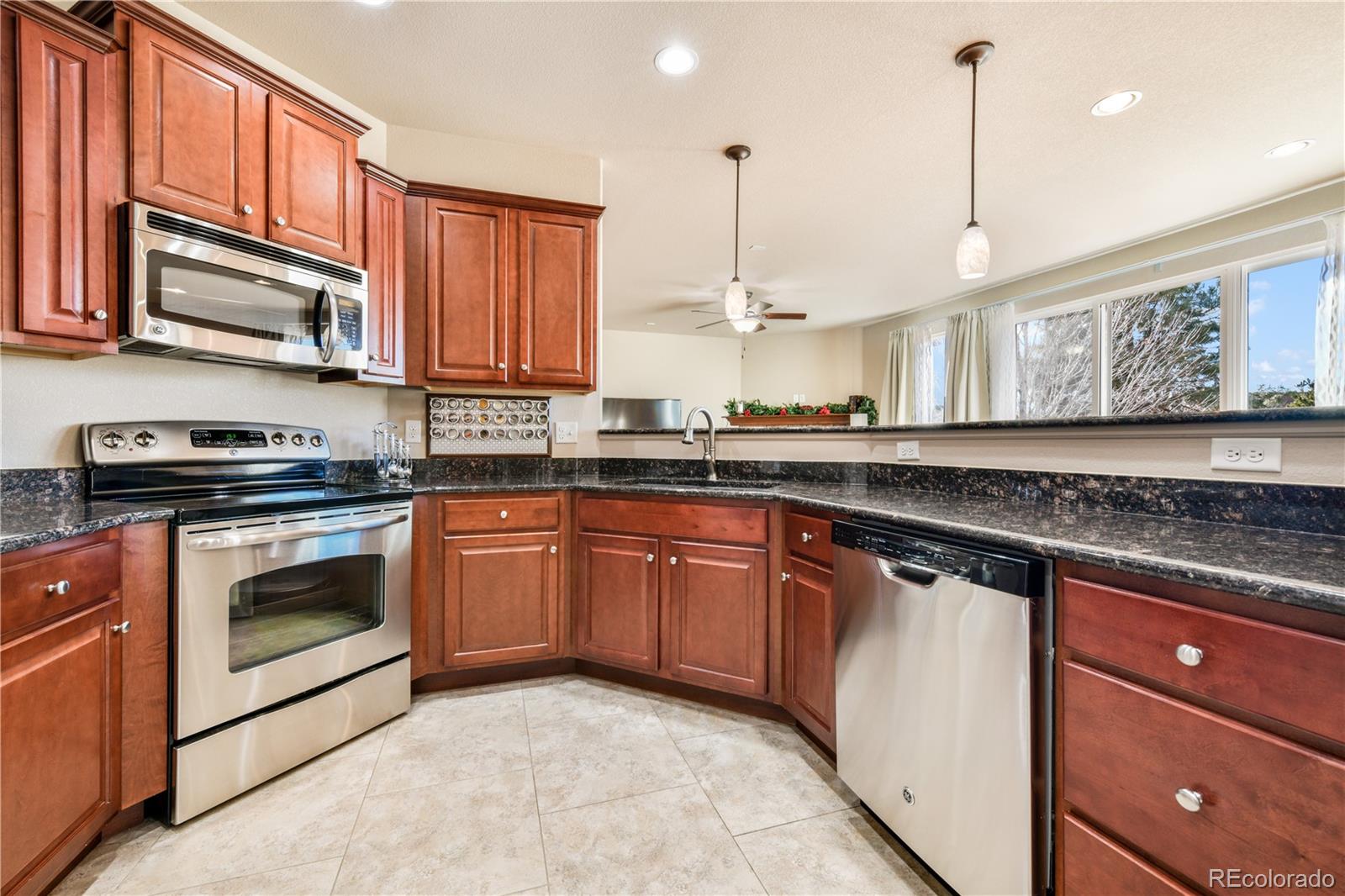 10484 Mile Post Loop Fountain, CO 80817 - Photo 14 of 50 a kitchen with stainless steel appliances granite countertop a stove a sink and a microwave