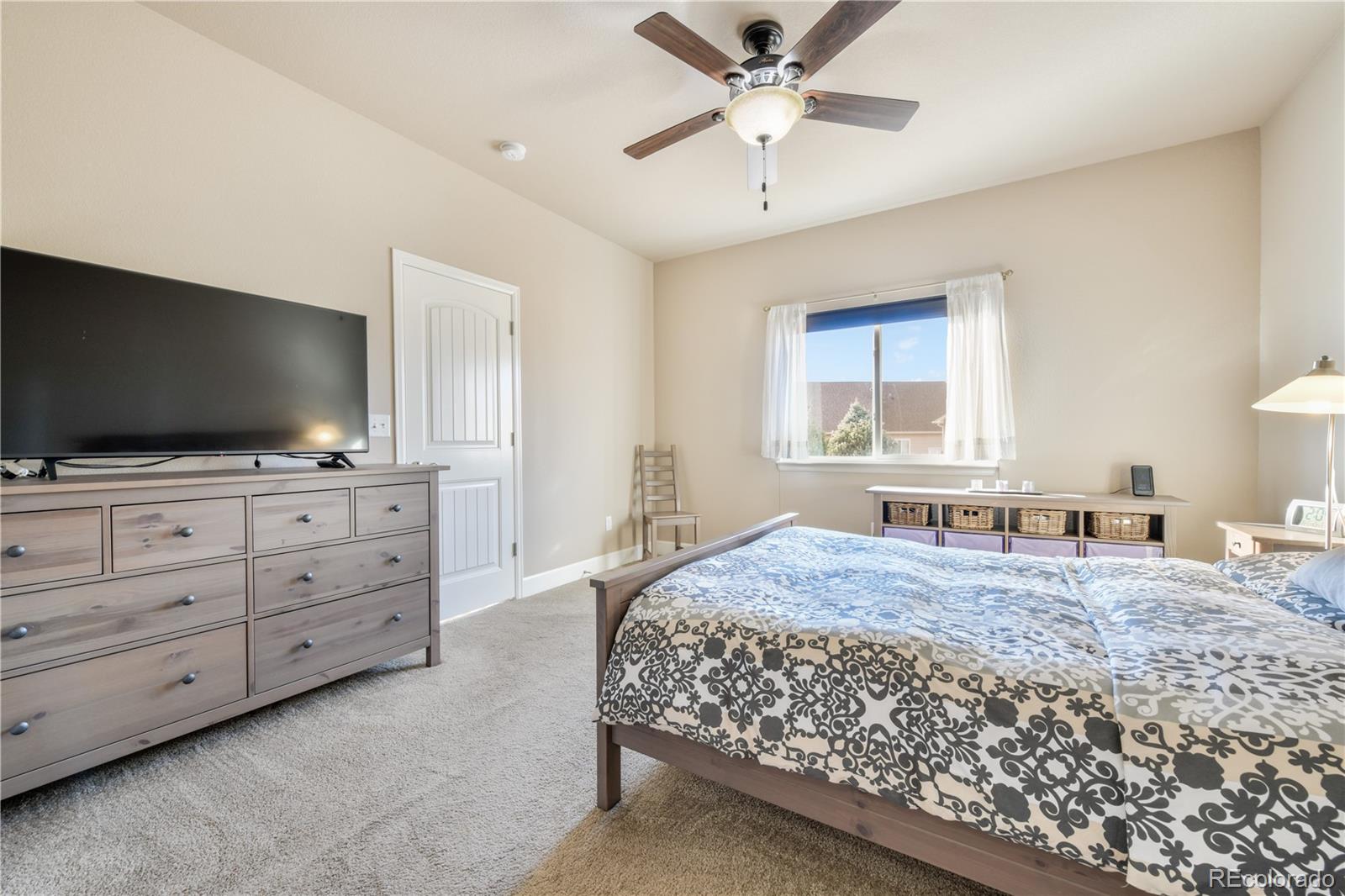 10484 Mile Post Loop Fountain, CO 80817 - Photo 18 of 50 a bedroom with a bed and a flat screen tv