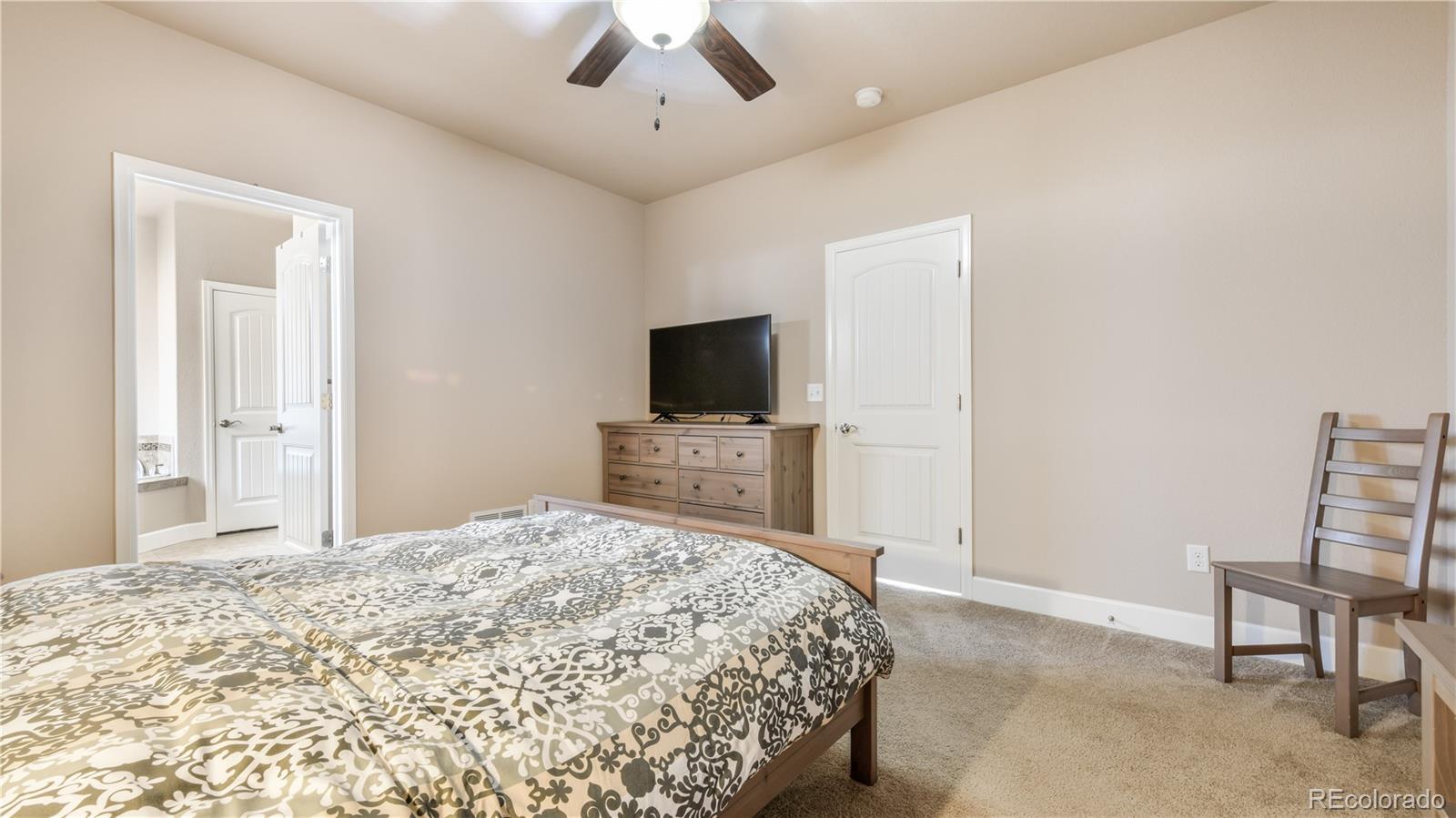 10484 Mile Post Loop Fountain, CO 80817 - Photo 19 of 50 a bedroom with a bed and a flat screen tv