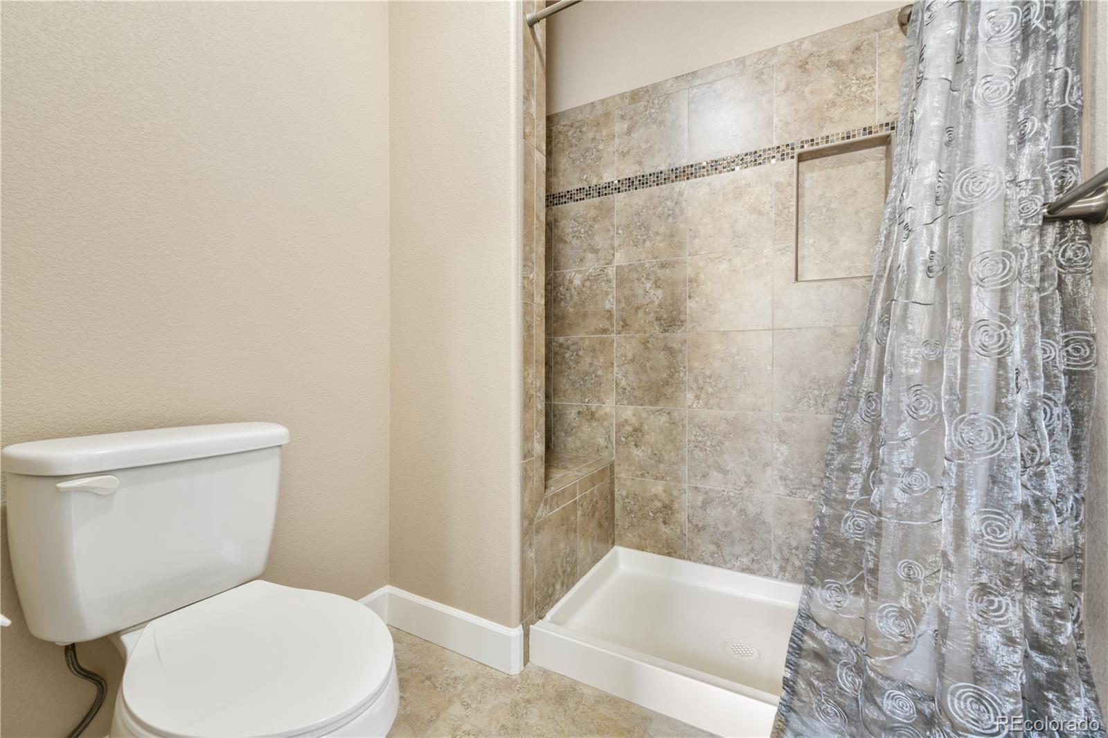 10484 Mile Post Loop Fountain, CO 80817 - Photo 22 of 50 a white toilet sitting next to a bath tub and a shower