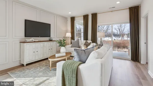 a living room with furniture a flat screen tv and a floor to ceiling window