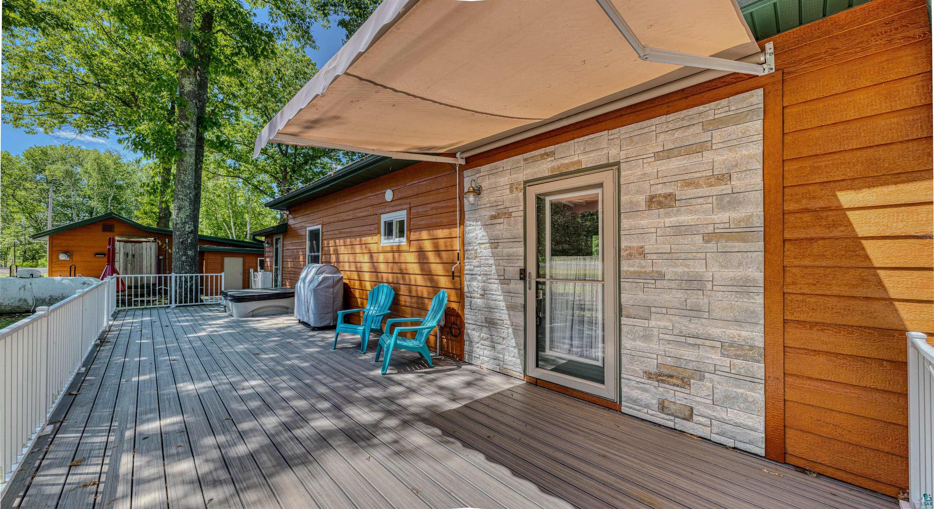 66075 Rooster Road Iron River, WI 54847 - Photo 31 of 52 Expansive outdoor deck featuring wood-finish flooring, white railing, and a retractable awning
