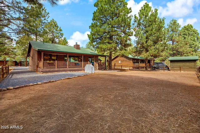 a view of a house with a small yard and wooden fence
