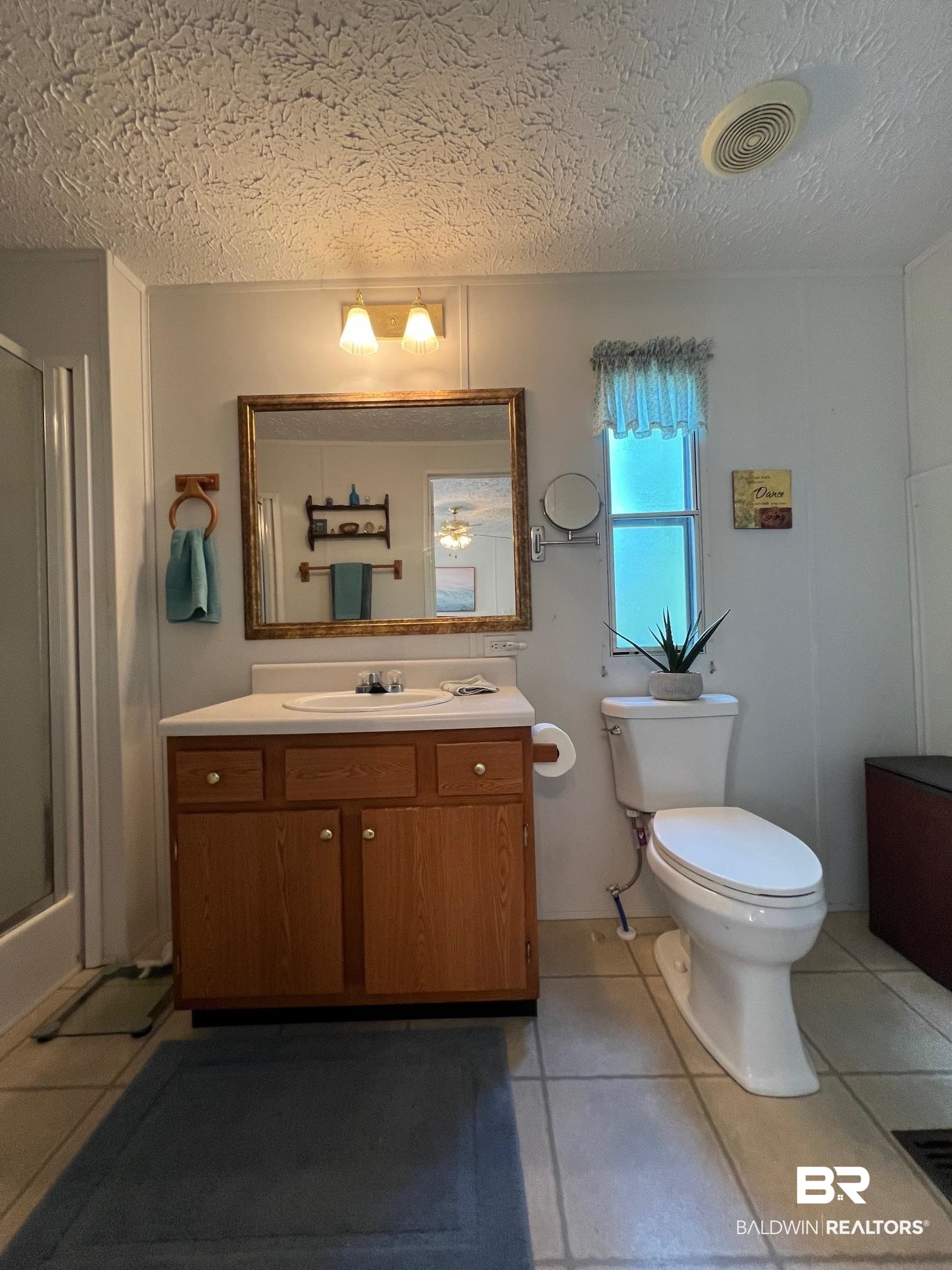 1936 Ridgewood Drive Lillian, AL 36549 - Photo 6 of 30 Full bath featuring visible vents, toilet, a shower stall, and tile patterned flooring
