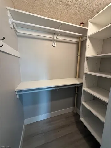 a view of walk in closet with empty racks