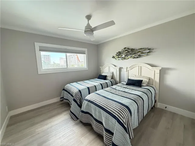 a bedroom with two beds and a chandelier