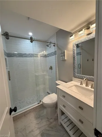 a bathroom with a double vanity sink toilet mirror and shower