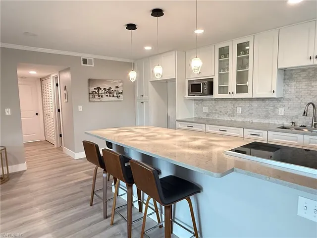 a kitchen with a table chairs sink and cabinets