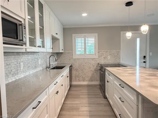 a kitchen with a sink stove top oven and refrigerator