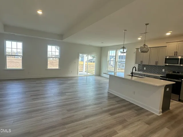 a large white kitchen with wooden floors and white walls