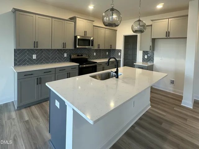 a kitchen with kitchen island a counter space a sink and appliances