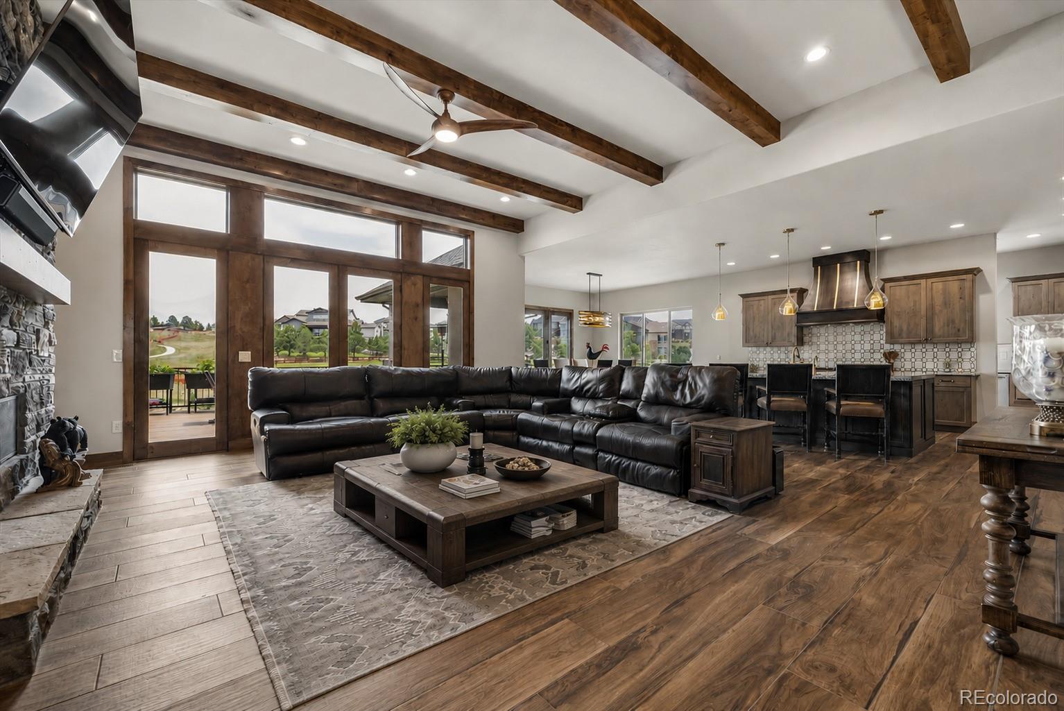 5754 Powell Road Parker, CO 80134 - Photo 5 of 43 a living room with furniture a rug kitchen view and a large window