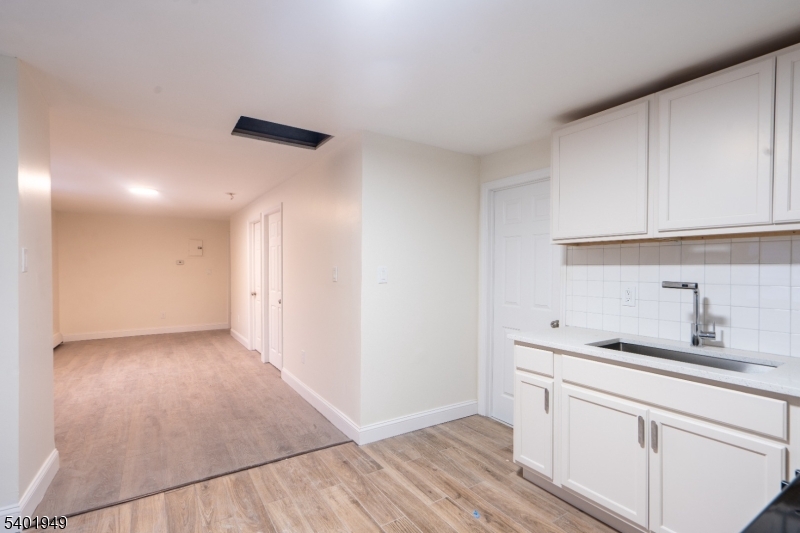445 Summer Street Paterson, NJ 07501 - Photo 3 of 12 a kitchen with a sink cabinets and a window
