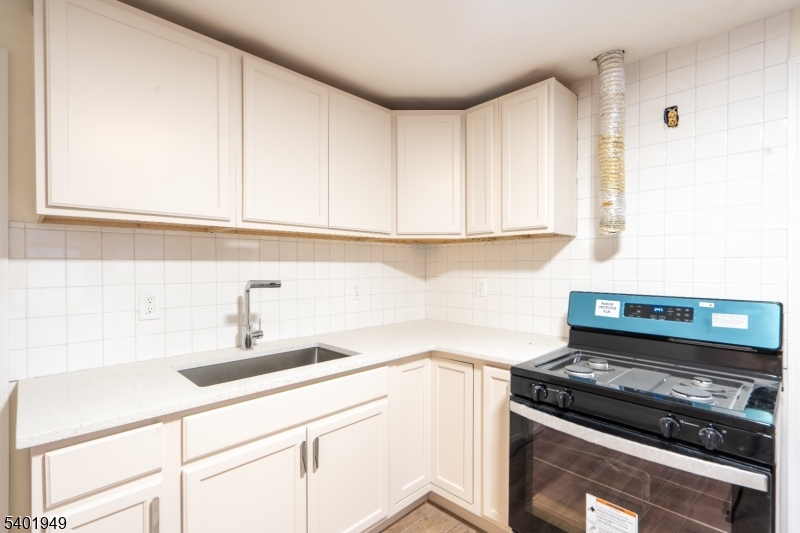 445 Summer Street Paterson, NJ 07501 - Photo 4 of 12 a kitchen with a sink and cabinets