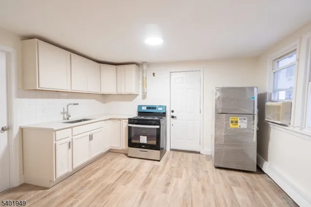 a kitchen with granite countertop a refrigerator stove and sink