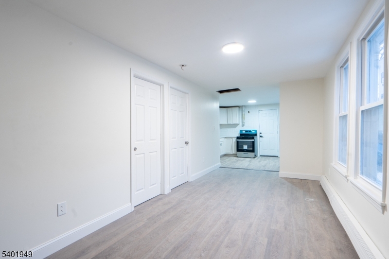 445 Summer Street Paterson, NJ 07501 - Photo 6 of 12 a view of a hallway with wooden floor and a living room