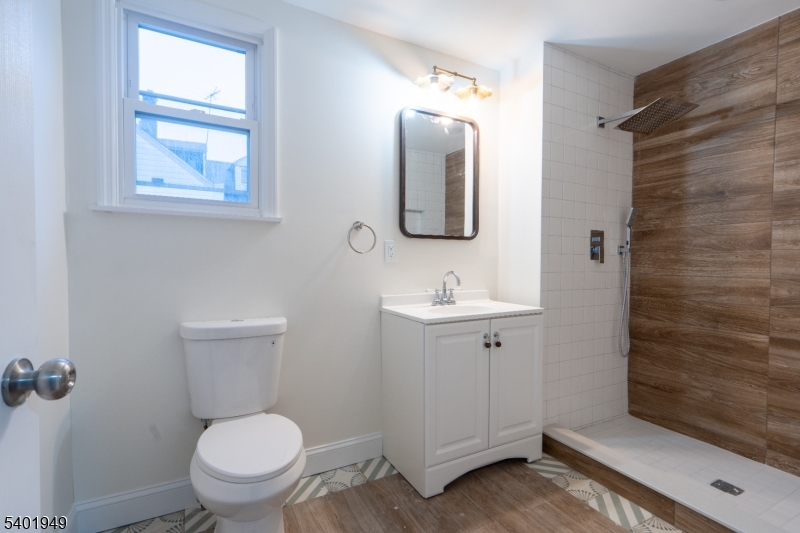 445 Summer Street Paterson, NJ 07501 - Photo 8 of 12 a bathroom with a toilet sink and mirror