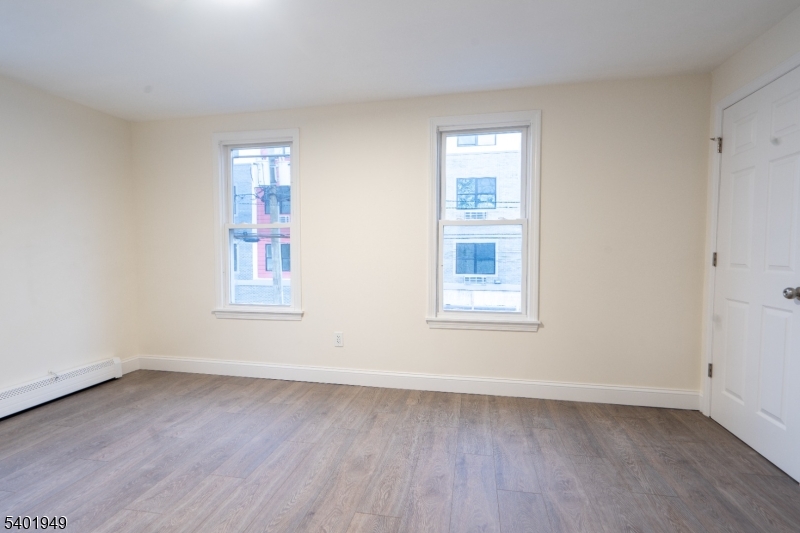 445 Summer Street Paterson, NJ 07501 - Photo 10 of 12 an empty room with wooden floor and windows