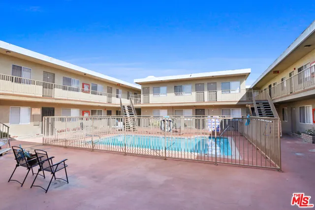 a view of a patio with table and chairs with wooden floor and fence