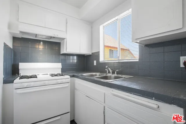 a kitchen with a stove cabinets and sink