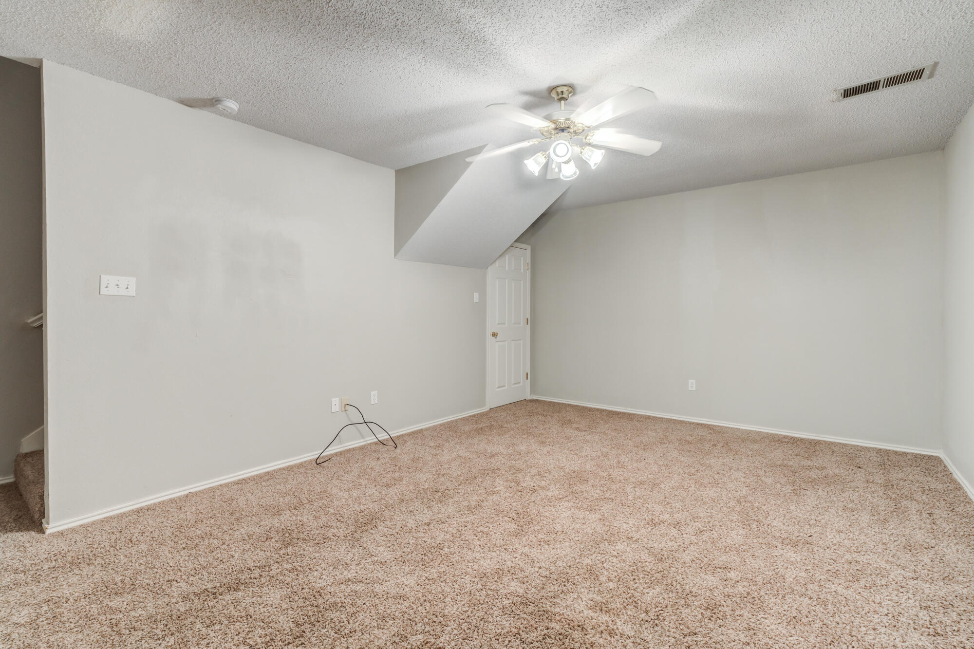 3425 97th Street Lubbock, TX 79423 - Photo 14 of 22 an empty room with a chandelier fan and windows