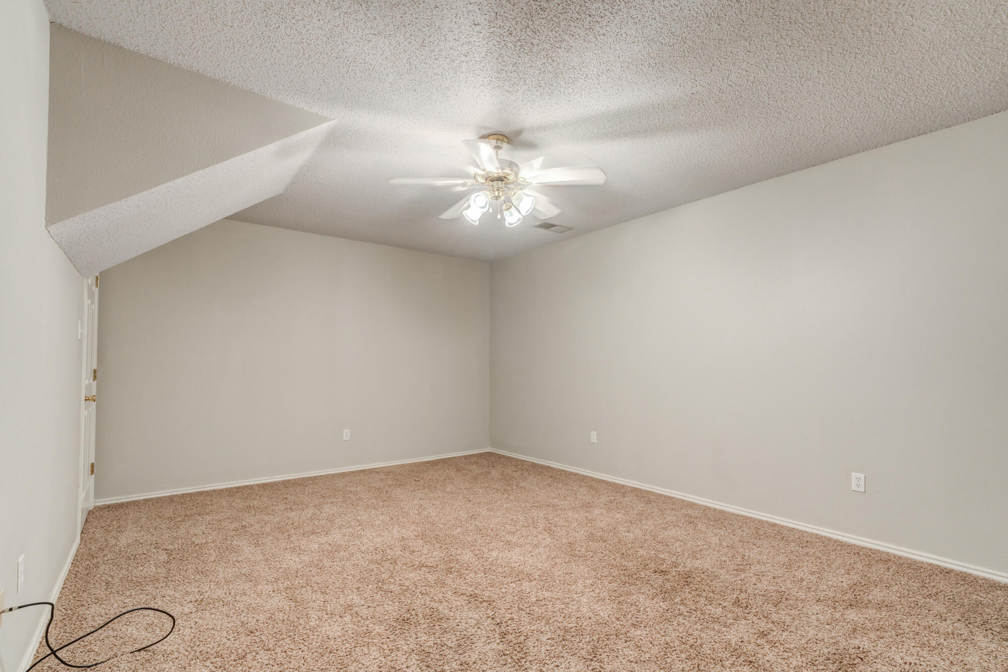 3425 97th Street Lubbock, TX 79423 - Photo 19 of 22 an empty room with a chandelier fan and windows