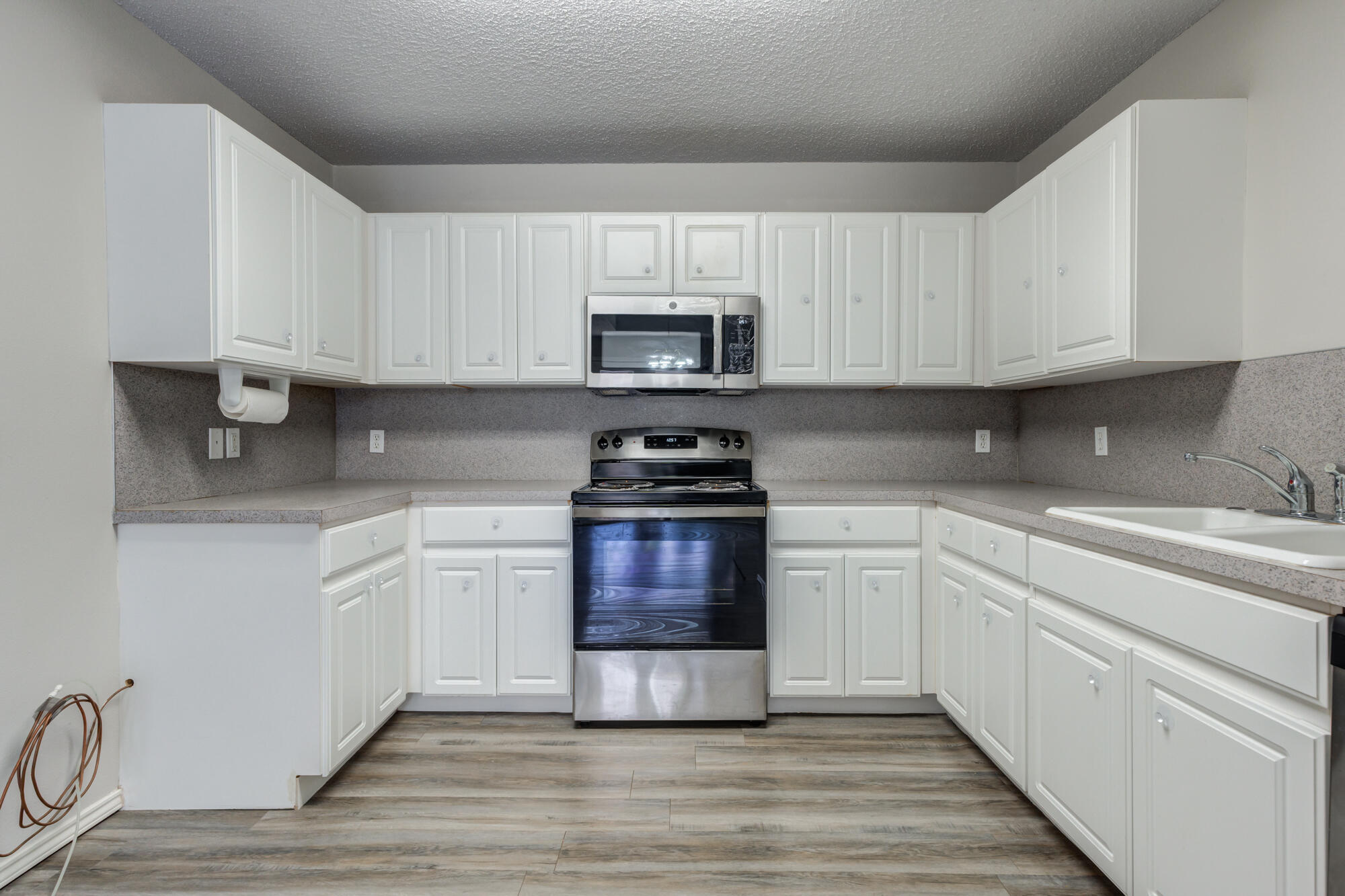 3425 97th Street Lubbock, TX 79423 - Photo 4 of 22 a kitchen with granite countertop a stove top oven sink and cabinets