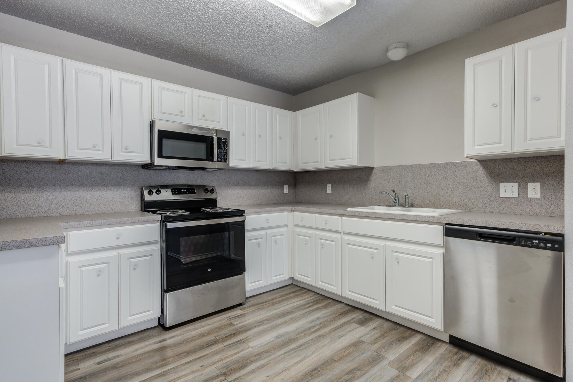 3425 97th Street Lubbock, TX 79423 - Photo 5 of 22 a kitchen with granite countertop white cabinets and stainless steel appliances