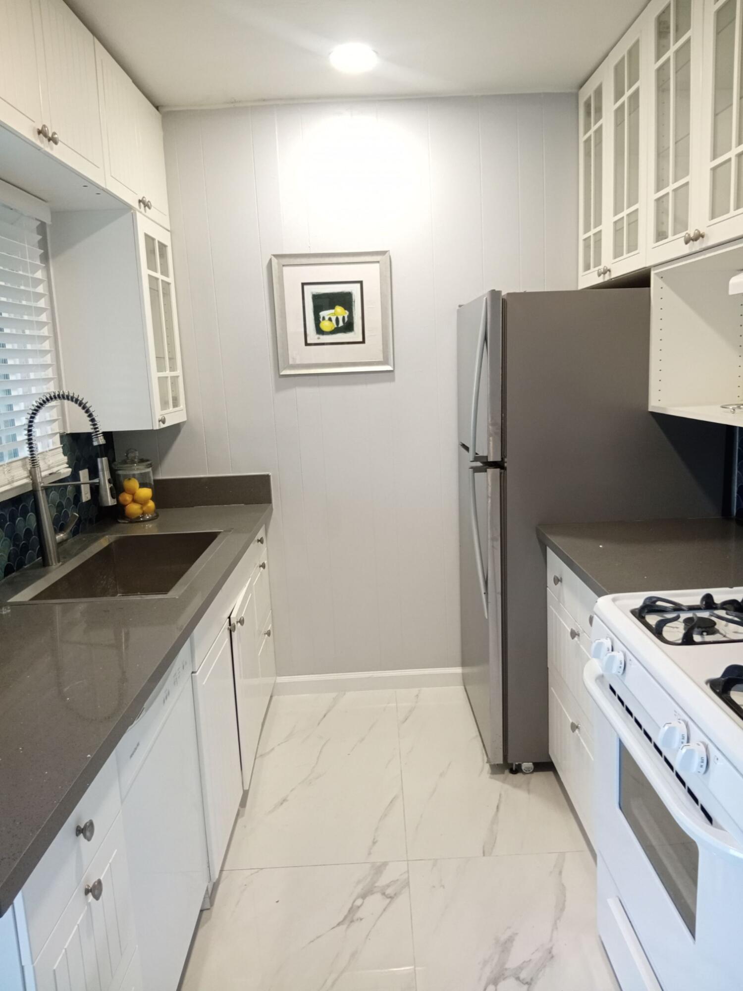 315 East Stevens Road, Unit 4 Palm Springs, CA 92262 - Photo 3 of 12 a kitchen with a sink stove and refrigerator