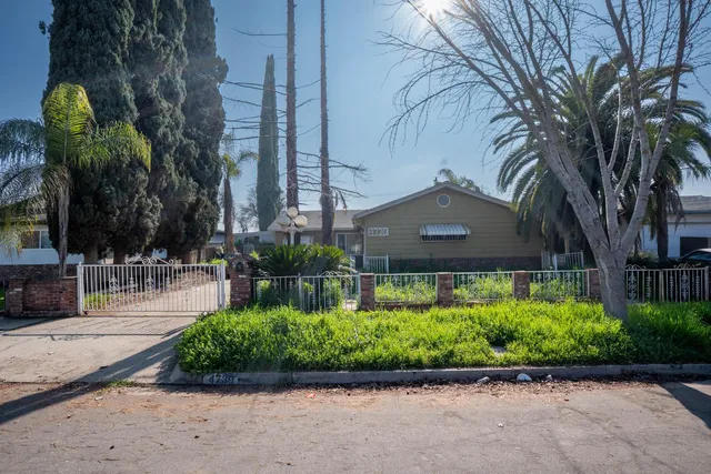 a front view of a house with a yard and potted plants