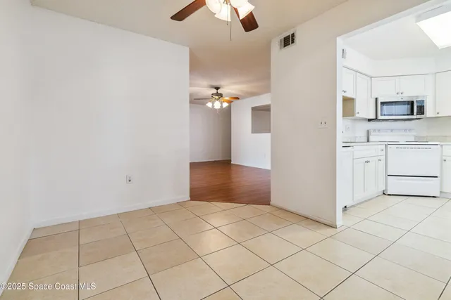 a view of kitchen with granite countertop cabinets and white appliances