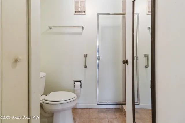a bathroom with a toilet and a shower