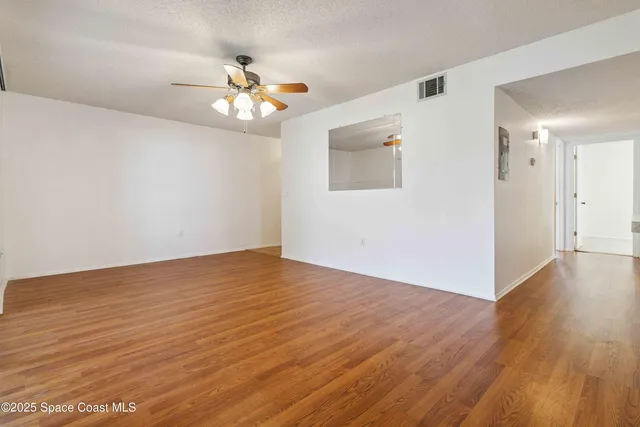 a view of an empty room with wooden floor