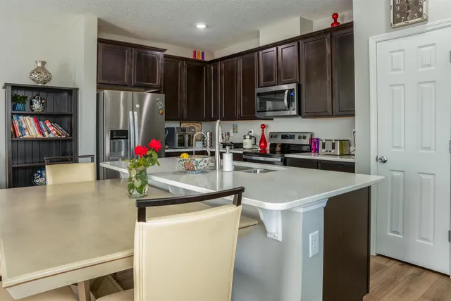 a kitchen with stainless steel appliances granite countertop a refrigerator a stove top oven a sink and dishwasher