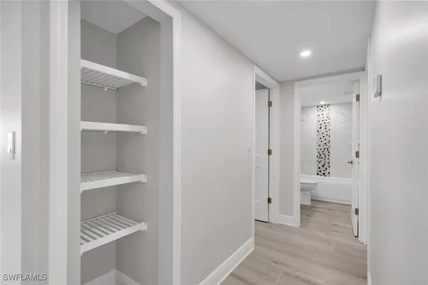 a view of walk in closet with wooden floor