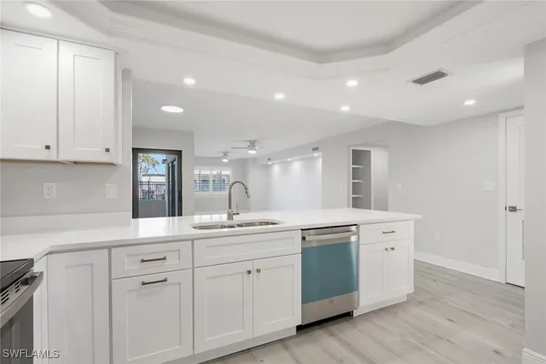 a kitchen with white cabinets and sink