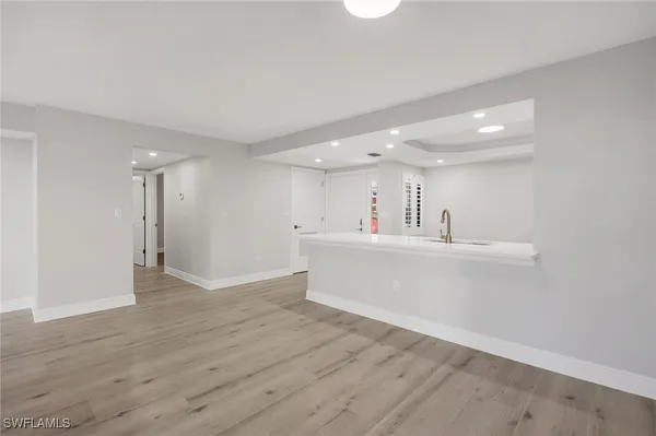 a view of a kitchen with wooden floor and a sink