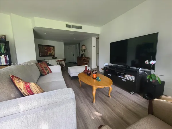 a living room with furniture and a wooden floor