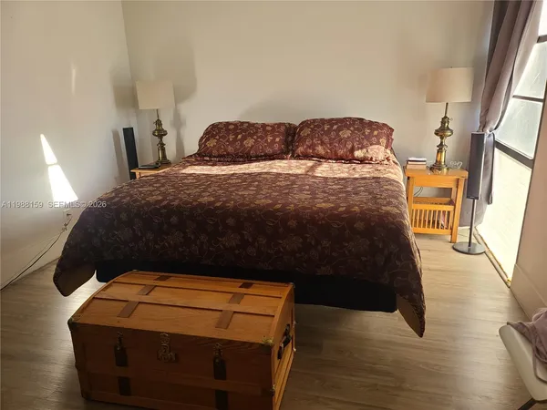 a bedroom with a bed and wooden floor