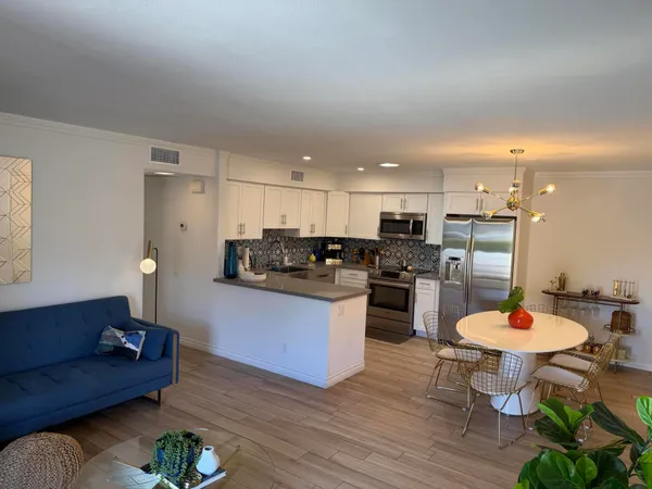 a living room with stainless steel appliances kitchen island granite countertop furniture and a kitchen view