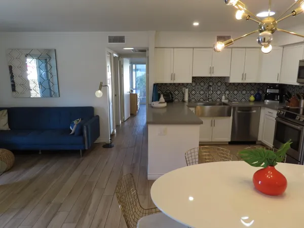 a kitchen with stainless steel appliances kitchen island granite countertop a stove a sink and a white cabinets