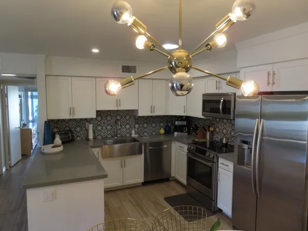 a kitchen with a sink stainless steel appliances kitchen island a table and chairs