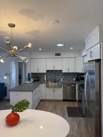 a kitchen with stainless steel appliances granite countertop a sink a stove a refrigerator and a cabinets