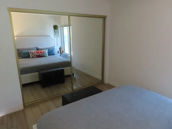 a bedroom with a bed and a mirror on dresser